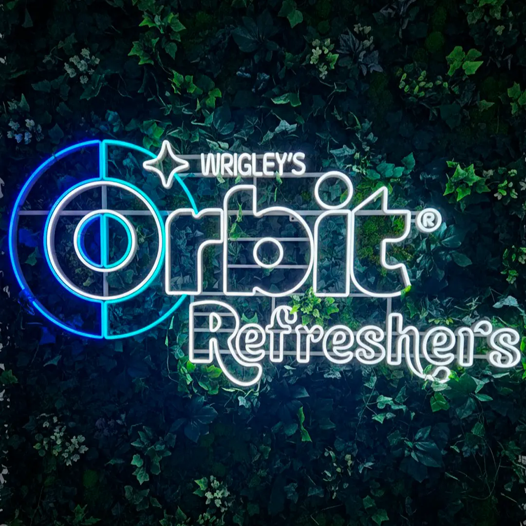 Neon LED z logo Orbit Wrigley's Refreshers na ścianie z zielonym mchem — realizacja Ledeon