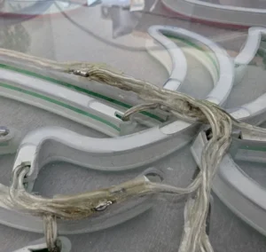 Neon LED konkurencji — przewody klejone z tyłu podkładu z plexi, nieestetyczne połączenia i widoczne kleje