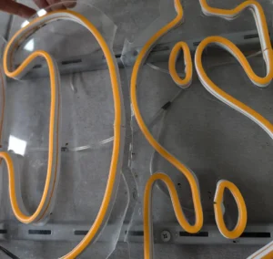Neon LED na stelażu z plexi — widoczne pęknięcia i żółknięcie materiału po czasie
